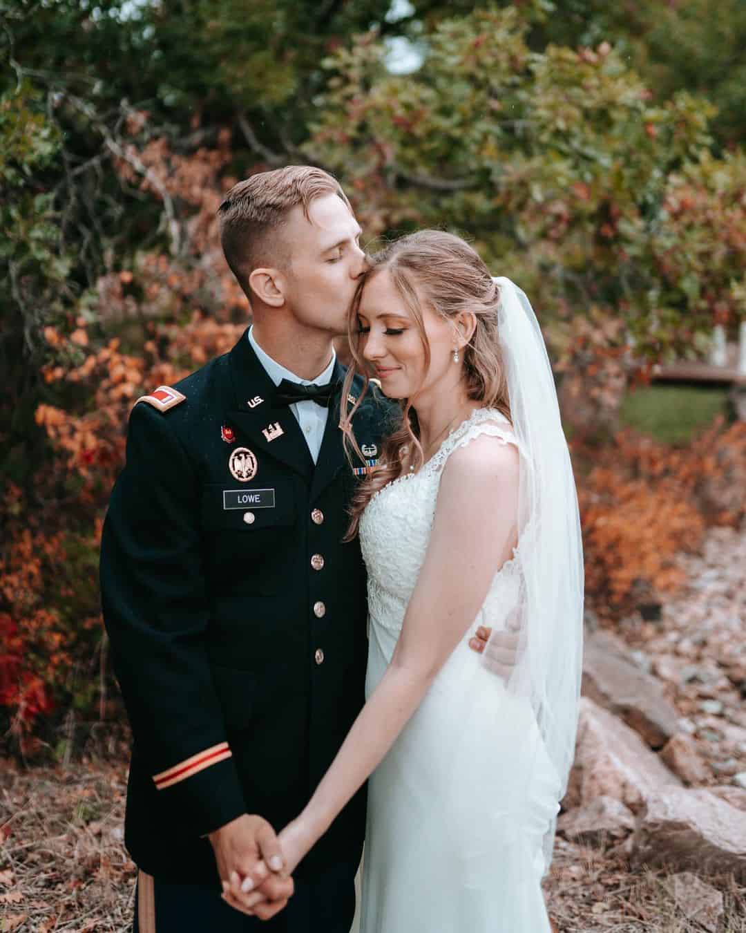 military wedding at creekside event center with groom kissing bride on forehead