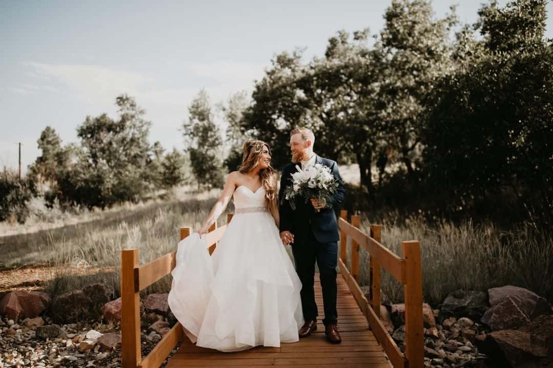 the bridge at creekside event center with a wedding couple